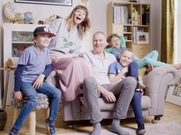 Happy family of five laughing on the sofa